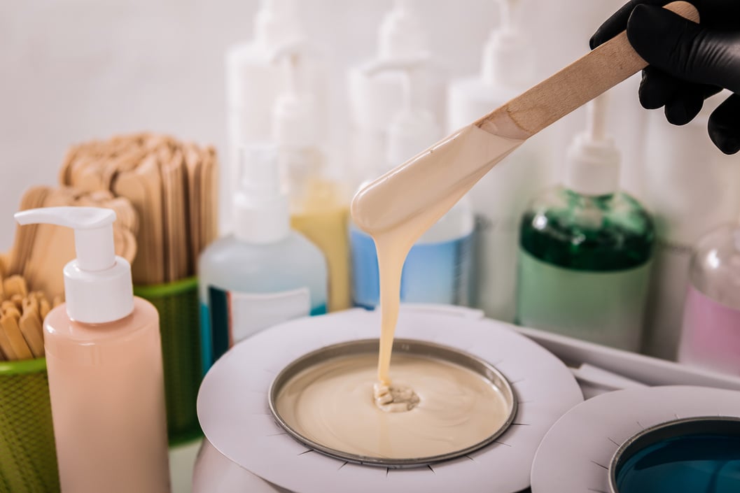 Master in hair removal preparing wax before removing hair